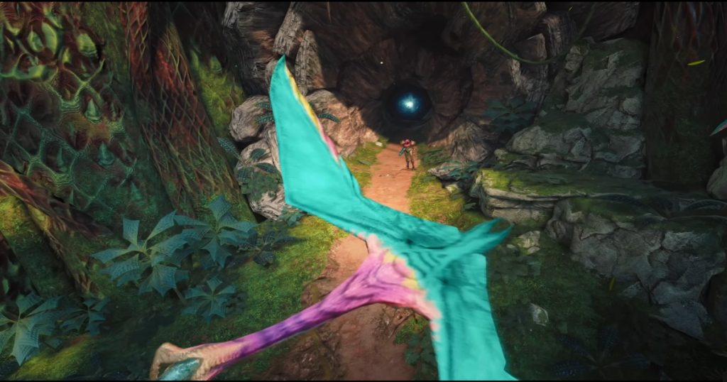 A colorful, winged creature flies through a lush jungle path toward a cave entrance, where an armored figure stands near a glowing blue light deep inside the tunnel